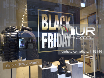 Promotional signage advertises up to 70% off for Black Friday at a clothing store in Bari, Italy, on November 29, 2024. The image highlights...