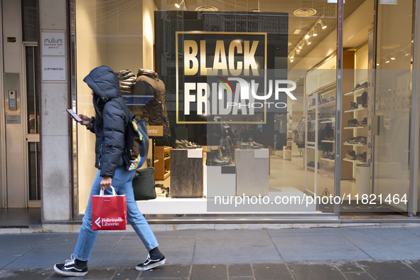 Promotional signage advertises up to 70% off for Black Friday at a clothing store in Bari, Italy, on November 29, 2024. The image highlights...