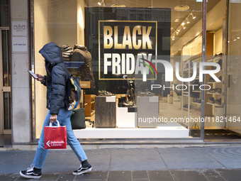 Promotional signage advertises up to 70% off for Black Friday at a clothing store in Bari, Italy, on November 29, 2024. The image highlights...