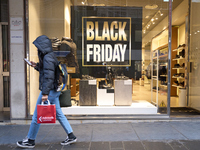 Promotional signage advertises up to 70% off for Black Friday at a clothing store in Bari, Italy, on November 29, 2024. The image highlights...