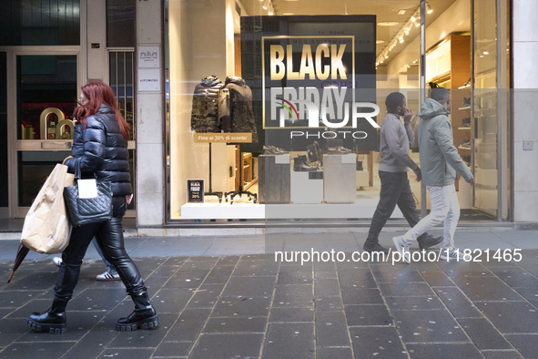 Promotional signage advertises up to 70% off for Black Friday at a clothing store in Bari, Italy, on November 29, 2024. The image highlights...