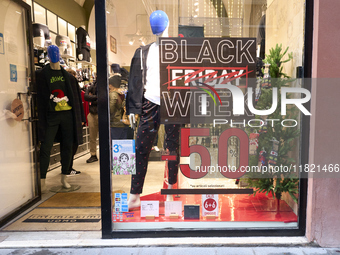 Promotional signage advertises up to 70% off for Black Friday at a clothing store in Bari, Italy, on November 29, 2024. The image highlights...