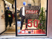 Promotional signage advertises up to 70% off for Black Friday at a clothing store in Bari, Italy, on November 29, 2024. The image highlights...