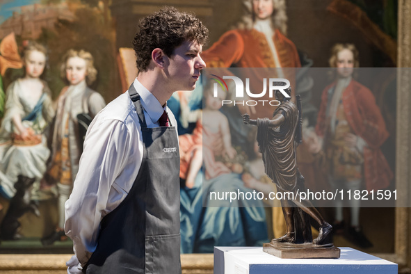 LONDON, UNITED KINGDOM - NOVEMBER 29, 2024: An art handler looks at a sculpture titled 'Apollo Belvedere' attributed to Gianfrancesco Susini...