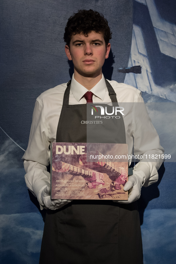 LONDON, UNITED KINGDOM - NOVEMBER 29, 2024: An art handler holds The Dune Bible an extraordinary artefact from Alejandro Jodorowsky's epic D...