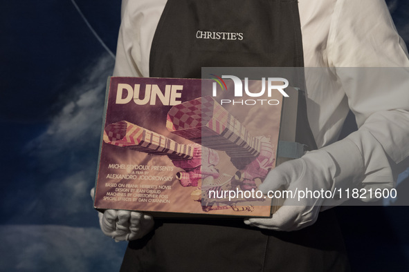 LONDON, UNITED KINGDOM - NOVEMBER 29, 2024: An art handler holds The Dune Bible an extraordinary artefact from Alejandro Jodorowsky's epic D...