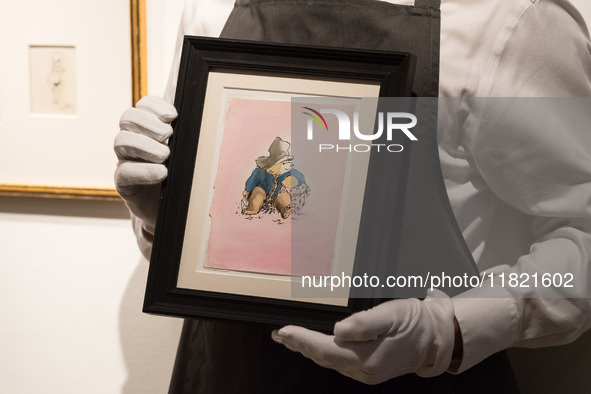 LONDON, UNITED KINGDOM - NOVEMBER 29, 2024: An art handler holds a drawing of Paddington Bear by Peggy Fortnum, With love from Paddington (e...