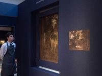 LONDON, UNITED KINGDOM - NOVEMBER 29, 2024: An art handler looks at a painting by Anthony van Dyck 'A wooded landscape a sketch' hidden on t...