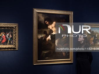 LONDON, UNITED KINGDOM - NOVEMBER 29, 2024: A staff member looks at a painting by Luca Giordano (Naples 1634-1705) titled 'The Martyrdom of...