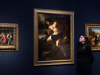 LONDON, UNITED KINGDOM - NOVEMBER 29, 2024: A staff member looks at a painting by Luca Giordano (Naples 1634-1705) titled 'The Martyrdom of...