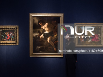 LONDON, UNITED KINGDOM - NOVEMBER 29, 2024: A staff member stands next to paintings by Alessandro Turchi, Called L'orbetto (Verona 1578-1649...