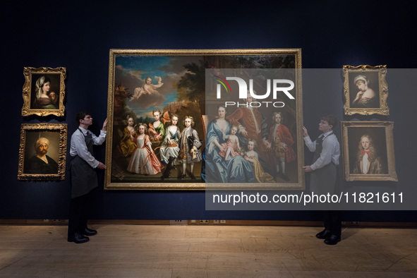 LONDON, UNITED KINGDOM - NOVEMBER 29, 2024: Art handlers hold a painting by James Maubert (Ireland 1666-1746 London) titled 'Group portrait...