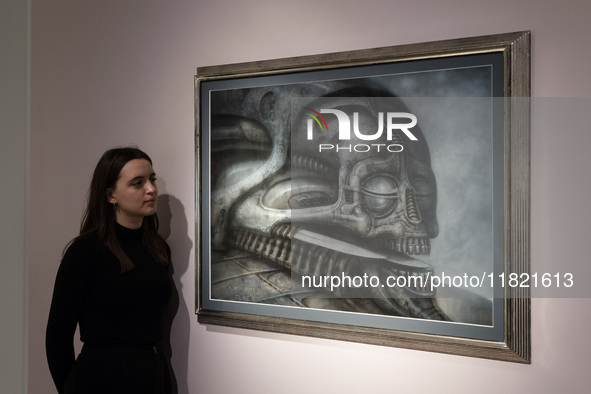 LONDON, UNITED KINGDOM - NOVEMBER 29, 2024: A staff member looks at a painting 'Dune VI' by H.R. Giger estimate: GBP40,000 - 60,000 during a...