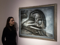 LONDON, UNITED KINGDOM - NOVEMBER 29, 2024: A staff member looks at a painting 'Dune VI' by H.R. Giger estimate: GBP40,000 - 60,000 during a...