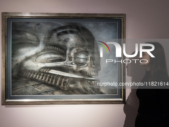 LONDON, UNITED KINGDOM - NOVEMBER 29, 2024: A staff member looks at a painting 'Dune VI' by H.R. Giger estimate: GBP40,000 - 60,000 during a...