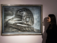 LONDON, UNITED KINGDOM - NOVEMBER 29, 2024: A staff member looks at a painting 'Dune VI' by H.R. Giger estimate: GBP40,000 - 60,000 during a...