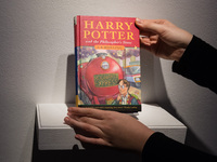 LONDON, UNITED KINGDOM - NOVEMBER 29, 2024: A staff member holds a true first edition of J.K. Rowling's Harry Potter and the Philosopher's S...