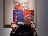 LONDON, UNITED KINGDOM - NOVEMBER 29, 2024: A staff member holds a true first edition of J.K. Rowling's Harry Potter and the Philosopher's S...