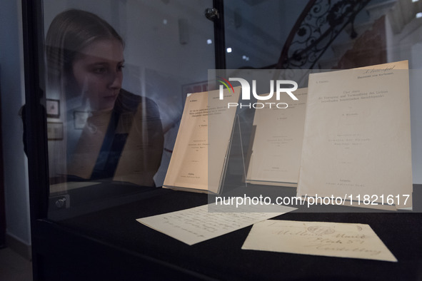 LONDON, UNITED KINGDOM - NOVEMBER 29, 2024: A staff member looks at exceptionally rare first edition, author's offprint issues, of Einstein'...