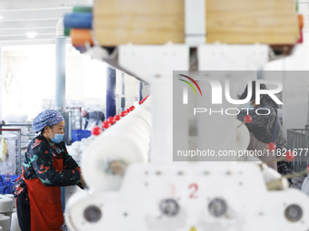 Workers work at a production workshop of a textile enterprise in Sihong Economic Development Zone in Suqian, Jiangsu province, China, on Nov...