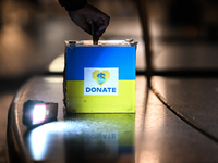 KRAKOW, POLAND - NOVEMBER 29:
A passerby drops a billet into a collection box on the 218th day of the Russian invasion of Ukraine as a few m...