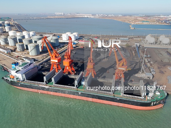 Cranes unload coal from cargo ships at Longkou port area of Yantai Port in East China's Shandong province on November 29, 2024. 