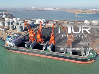 Cranes unload coal from cargo ships at Longkou port area of Yantai Port in East China's Shandong province on November 29, 2024. (