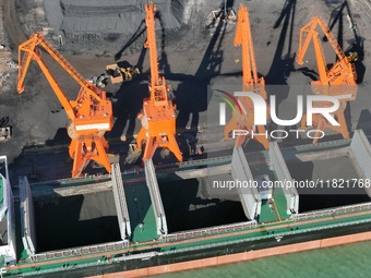 Cranes unload coal from cargo ships at Longkou port area of Yantai Port in East China's Shandong province on November 29, 2024. (