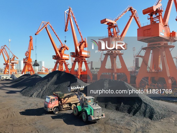 Cranes unload coal from cargo ships at Longkou port area of Yantai Port in East China's Shandong province on November 29, 2024. 