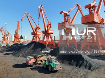 Cranes unload coal from cargo ships at Longkou port area of Yantai Port in East China's Shandong province on November 29, 2024. (