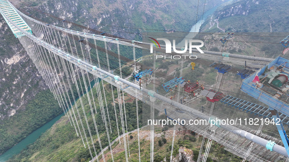 Workers work on the Huajiang Canyon Bridge in Qianxinan, Guizhou province, China, on November 30, 2024. The bridge is a steel girder suspens...