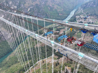 Workers work on the Huajiang Canyon Bridge in Qianxinan, Guizhou province, China, on November 30, 2024. The bridge is a steel girder suspens...