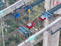 Workers work on the Huajiang Canyon Bridge in Qianxinan, Guizhou province, China, on November 30, 2024. The bridge is a steel girder suspens...