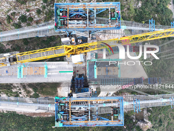 Workers work on the Huajiang Canyon Bridge in Qianxinan, Guizhou province, China, on November 30, 2024. The bridge is a steel girder suspens...