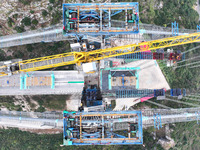 Workers work on the Huajiang Canyon Bridge in Qianxinan, Guizhou province, China, on November 30, 2024. The bridge is a steel girder suspens...