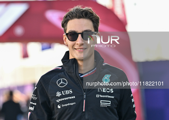 The British Formula One driver George Russell of Mercedes walks through the paddock as he arrives ahead of the Formula 1 Grand Prix of Qatar...