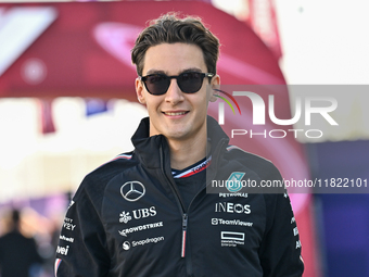 The British Formula One driver George Russell of Mercedes walks through the paddock as he arrives ahead of the Formula 1 Grand Prix of Qatar...