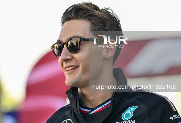 The British Formula One driver George Russell of Mercedes walks through the paddock as he arrives ahead of the Formula 1 Grand Prix of Qatar...