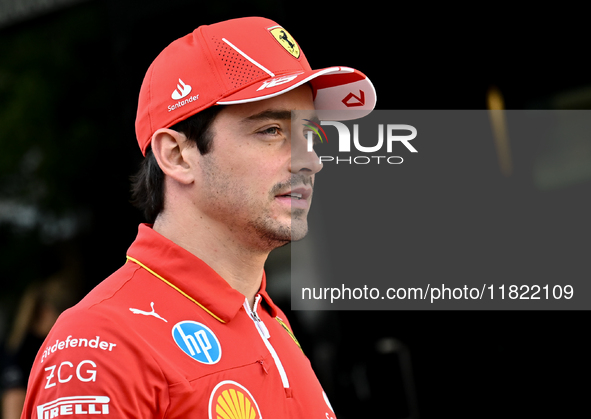 Monaco's Formula One driver Charles Leclerc of Ferrari walks through the paddock as he arrives ahead of the Formula 1 Grand Prix of Qatar at...