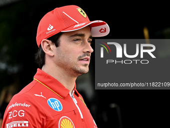 Monaco's Formula One driver Charles Leclerc of Ferrari walks through the paddock as he arrives ahead of the Formula 1 Grand Prix of Qatar at...