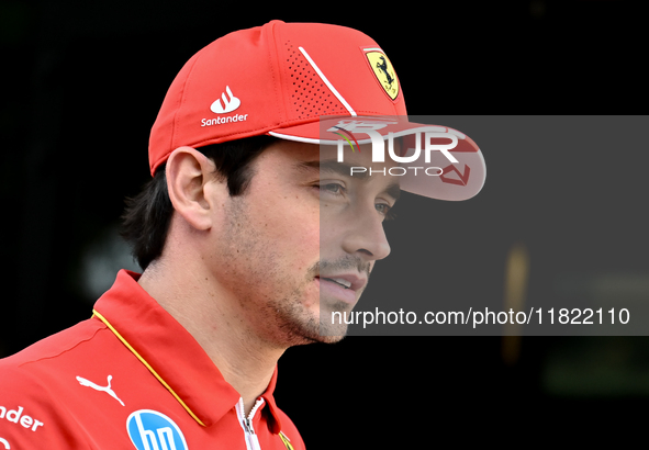 Monaco's Formula One driver Charles Leclerc of Ferrari walks through the paddock as he arrives ahead of the Formula 1 Grand Prix of Qatar at...