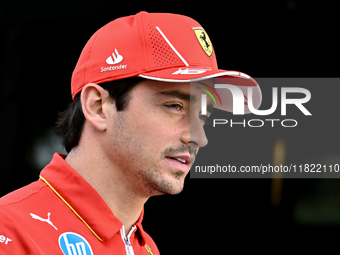 Monaco's Formula One driver Charles Leclerc of Ferrari walks through the paddock as he arrives ahead of the Formula 1 Grand Prix of Qatar at...