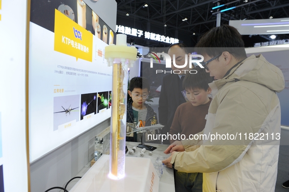 A staff member introduces a demonstration device for hydrothermal crystal growth to the audience at the 2024 Quantum Technology and Industry...