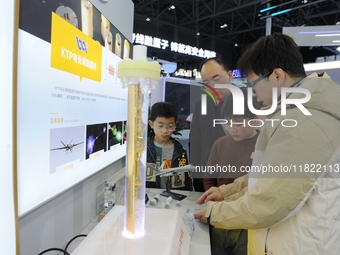 A staff member introduces a demonstration device for hydrothermal crystal growth to the audience at the 2024 Quantum Technology and Industry...