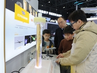 A staff member introduces a demonstration device for hydrothermal crystal growth to the audience at the 2024 Quantum Technology and Industry...