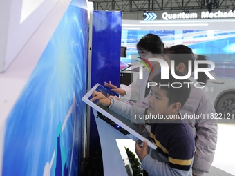 Visitors have a quantum blind box experience at the 2024 Quantum Technology and Industry Conference in Hefei, China, on November 30, 2024. (