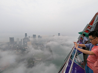 A foreigner takes a photograph of the city of Colombo amid smog and rain from Lotus Tower in Colombo, Sri Lanka, on November 30, 2024. Sri L...