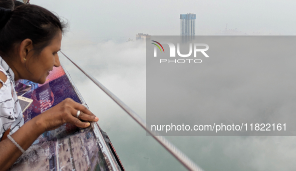 A woman looks at the city of Colombo amid smog and rain from Lotus Tower in Colombo, Sri Lanka, on November 30, 2024. Sri Lanka's Central En...