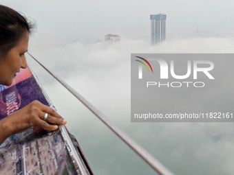 A woman looks at the city of Colombo amid smog and rain from Lotus Tower in Colombo, Sri Lanka, on November 30, 2024. Sri Lanka's Central En...