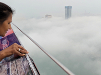 A woman looks at the city of Colombo amid smog and rain from Lotus Tower in Colombo, Sri Lanka, on November 30, 2024. Sri Lanka's Central En...